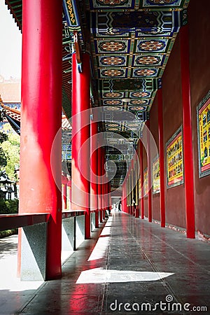 Vertical shot of an entrance of a Buddhist temple with red columns Stock Photo