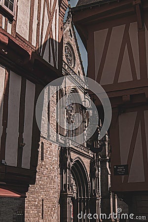 Vertical shot of the facade of Cathedral of the city of Vannes, France, seen through buildings Editorial Stock Photo