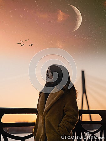 Vertical shot of a female standing by the fence on the background of moon and the starry sky Stock Photo