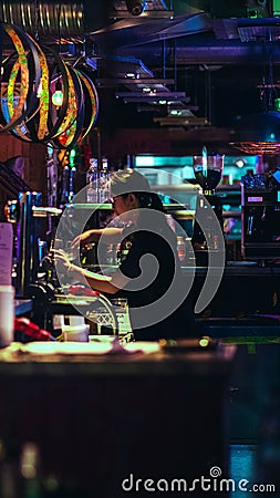 Vertical shot of a female worker in a bar with neon lights in Edinburgh, United Kingdom Editorial Stock Photo
