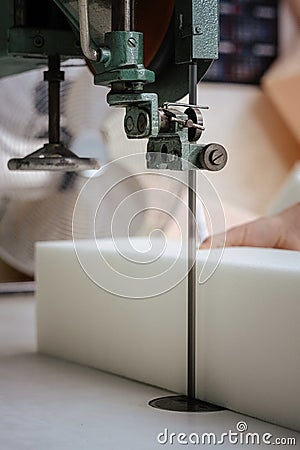 Vertical shot of a foam cutter machine, cutting through an upholstery foam Stock Photo