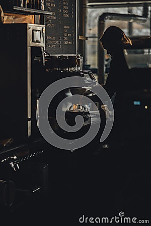 Vertical shot of a girl making coffee with an automatic pour-over machine. Editorial Stock Photo