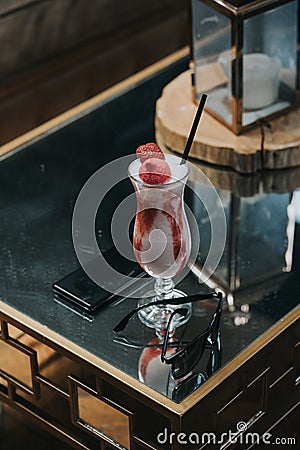 Vertical shot of a glass of strawberry smoothie on a table in a restaurant Stock Photo
