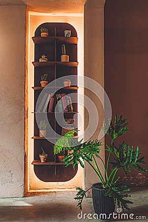 Vertical shot of a glowing illuminated shelf with books and plants in a cafe in Ho Chi Minh, Vietnam Editorial Stock Photo
