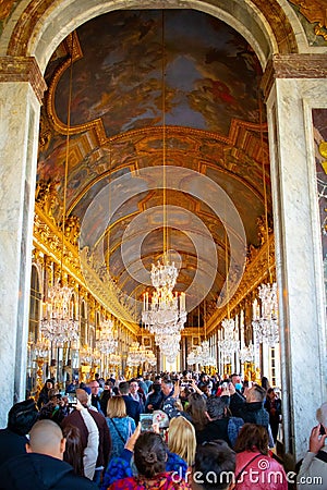 Vertical shot of the Hall of Mirrors at Versailles Palace in Paris, France packed with tourists Editorial Stock Photo