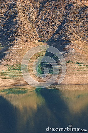 Vertical shot of hills reflecting on Azat Reservoir on a sunny day in Ararat, Armenia Stock Photo