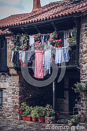 Vertical shot of laundry hanging from a balcony of a brick house Stock Photo