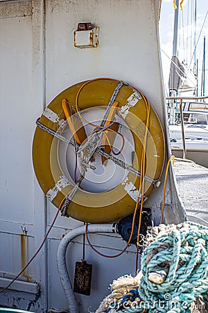 Vertical shot of a lifebuoy hanging on a wall of a boat on a port in Australia Stock Photo