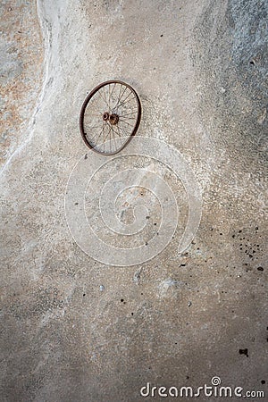 Vertical shot of a lone bicycle wheel stranded on the beach with low tides washing over it Stock Photo