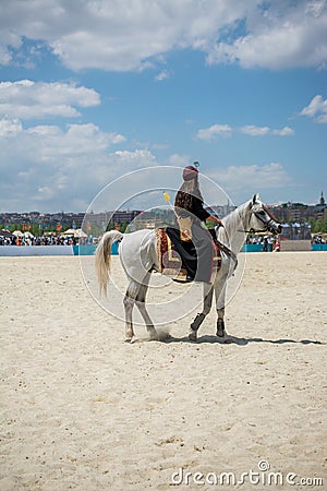 Vertical shot of a male riding on a white horse in the arena Editorial Stock Photo