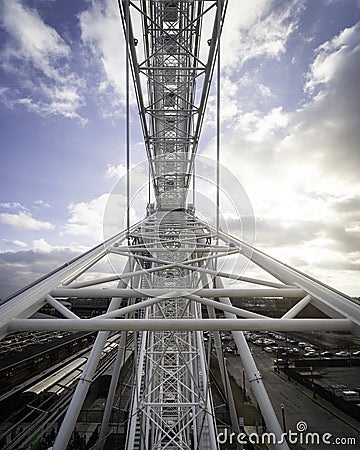 Vertical shot of a metallic construction part of Ferris wheel on a cloudy blue sky background Stock Photo