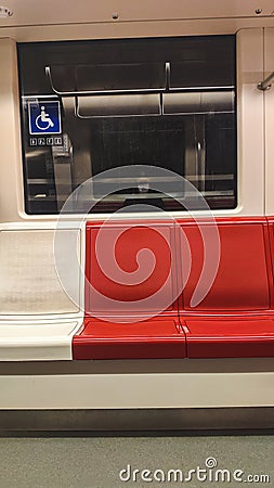 Vertical shot of modern seats in the train with a reflection of a human with a mask in the window Stock Photo