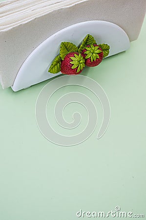 Vertical shot of a napkin holder with strawberry detail on green background with space for your text Stock Photo