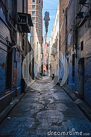 Vertical shot of a narrow walking street with garbage bins between buildings Editorial Stock Photo