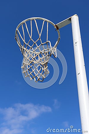 Vertical shot of a netball hoop against a blue sky Stock Photo