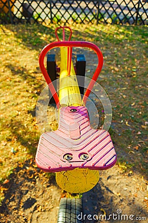 Vertical shot of an old colorful seesaw in a playground during daytime Stock Photo