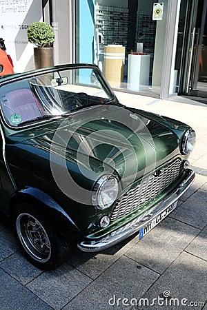 Vertical shot of an old green Mini Cooper parking in the city center of Hamburg Editorial Stock Photo