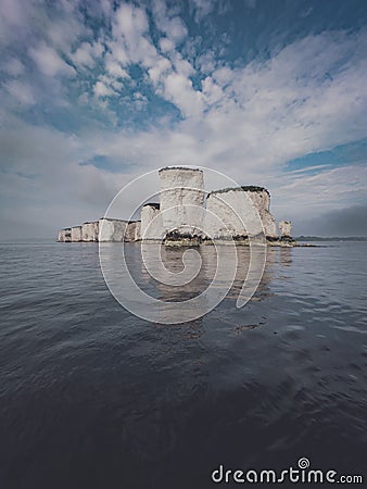 Vertical shot of Old Harry Rocks and a cloudy sky in the Isle of Purbeck, England Stock Photo