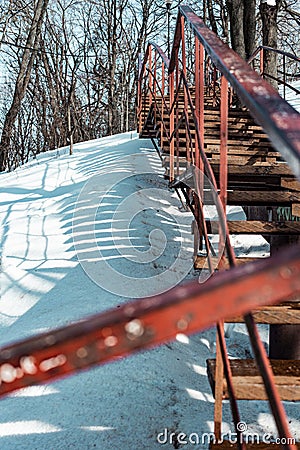 Vertical shot of an old rusty stairway in a snow-covered park Stock Photo