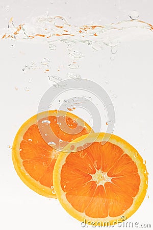 Vertical shot of orange slices bubbling in water Stock Photo