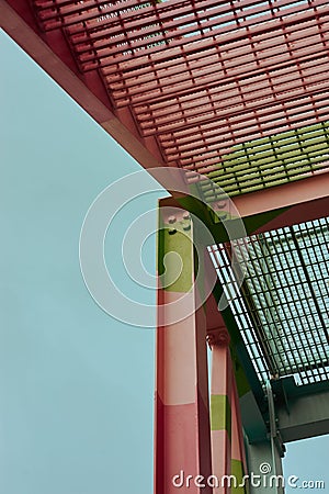 Vertical shot of a part of a pink and green metal walkway. Stock Photo