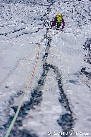 Vertical shot of a person climbing a rock in the Alps in Austria - overcoming challenges concept Stock Photo