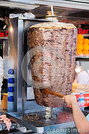 Vertical shot of a person preparing meat for Doner Kebab under the lights Editorial Stock Photo