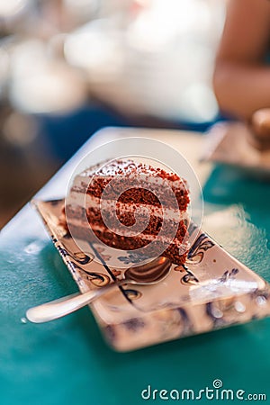 Vertical shot of a piece of a red velvet cake on a vintage patterned tray with a spoon Stock Photo