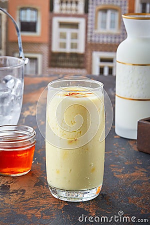 Vertical shot of of pina colada honey smoothie in a big glass with blur background Stock Photo