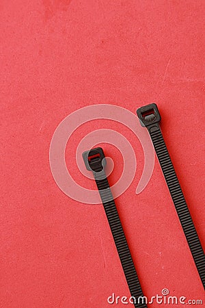 Vertical shot of plastic clamps isolated on a red background Stock Photo