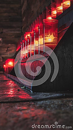 Vertical shot of red candles in the church of O Cebreiro Stock Photo