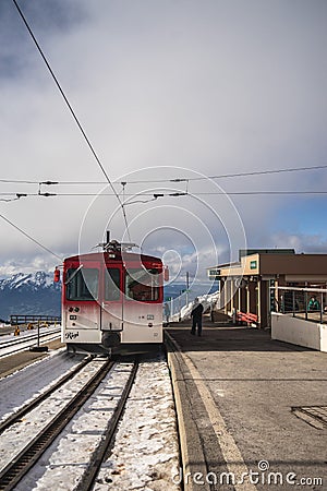 Vertical shot of a red cogwheel train during winter under a cloudy sky Editorial Stock Photo