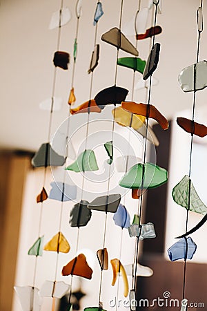 Vertical shot of rows of artistic wind chimes decoration made with colorful broken pieces of glass Stock Photo