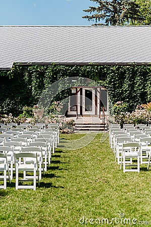 Vertical shot of the rows of chairs on the lawn outside for a wedding ceremony Stock Photo