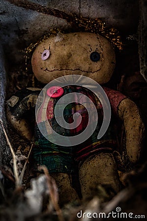 Vertical shot of a scary dirty stuffed doll on the ground Stock Photo
