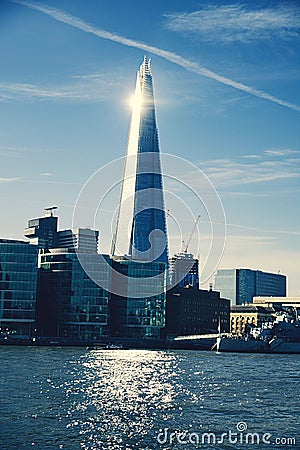 Vertical shot of the Shard skyscraper from the water under a blue sky in London, UK. Editorial Stock Photo