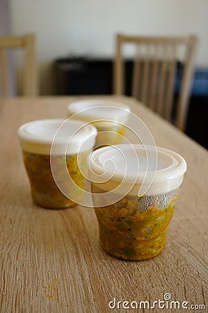 Vertical shot of small containers filled with baby food Stock Photo