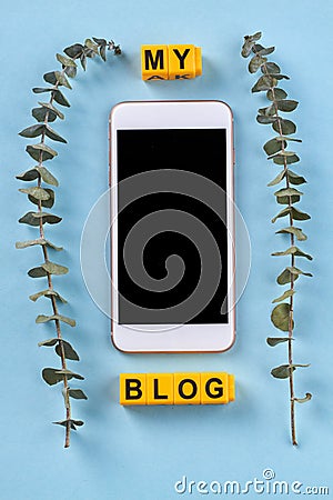 Vertical shot of smartphone with cube letters and branches. Stock Photo