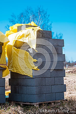 Vertical shot of a stack of gray bricks near a construction site Stock Photo