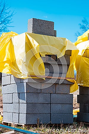 Vertical shot of a stack of gray bricks near a construction site Stock Photo