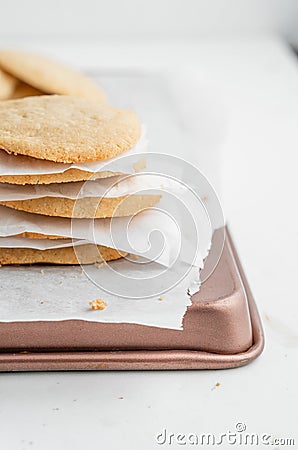 Vertical shot of a stack of homemade cookies with white napkins on a tray Stock Photo