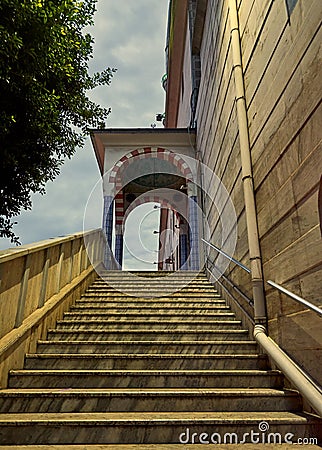 Vertical shot of stairs leading up to a decorative arched dome entrance Stock Photo