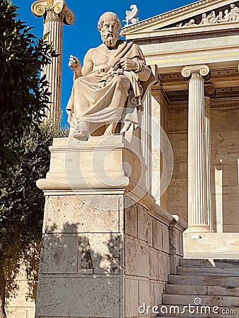 Vertical shot of a statue by the entrance of Academy of Athens university in Athens, Greece Stock Photo