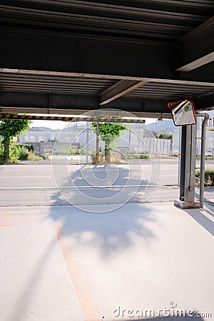 Vertical shot of the street from inside a parking garage, with a convex mirror in the corner Stock Photo