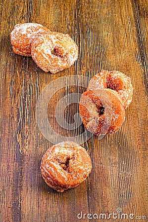 Vertical shot of sugary donuts on a wooden surface Stock Photo