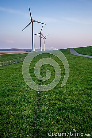 Vertical shot of tall wind-turbines along the Westermeerdijk in the Netherlands Stock Photo
