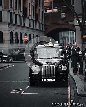 Vertical shot of a taxi waiting on a crowded street in London, UK Editorial Stock Photo