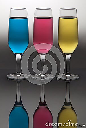 Vertical shot of three champagne flute glass with colorful liquids Stock Photo