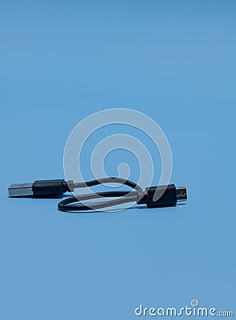 Vertical shot of type A to Micro USB cable on a blue background Stock Photo