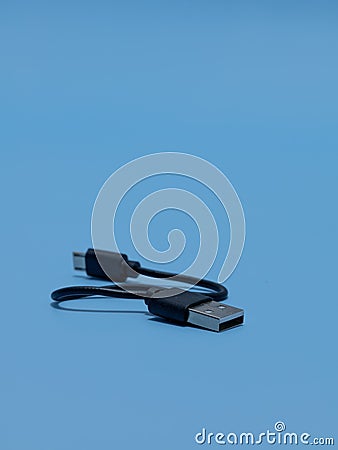 Vertical shot of type A to Micro USB cable on a blue background Stock Photo